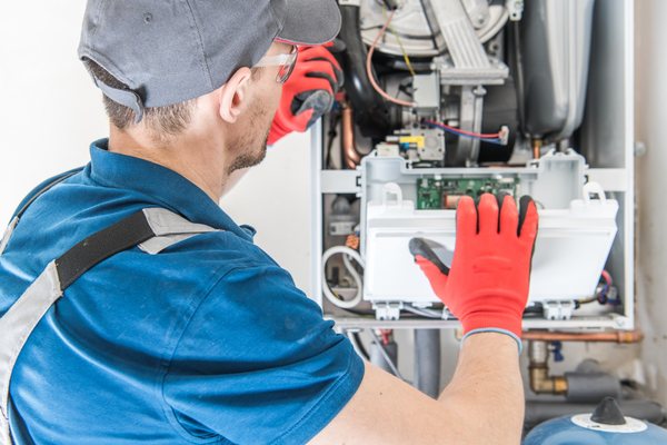 Technician repairing a residential furnace for furnace repair service.