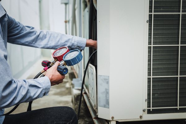 Technician checking an HVAC system with service gauges during heating repair.