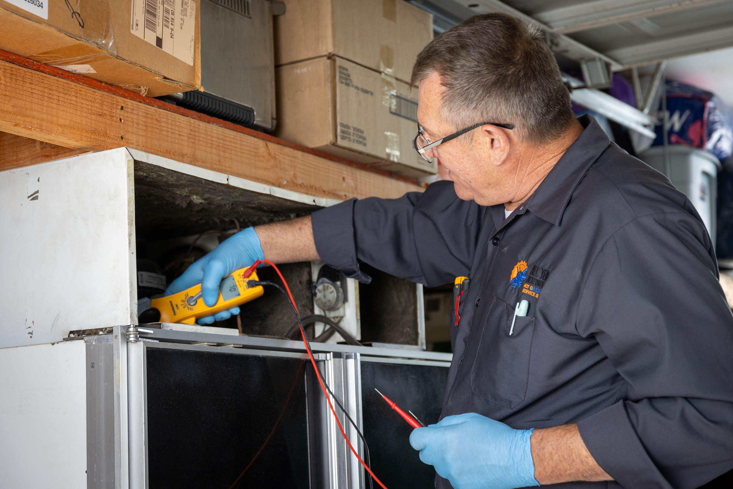 All Year Heating & Air technician performing an electrical diagnostic for freezer repair service